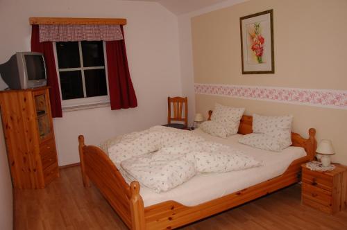 a bedroom with a bed and a television in it at Biohof Ebenbauer in Waidhofen an der Ybbs