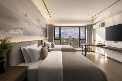 a hotel room with two beds and a television at 雲幔宋居 in Lijiang