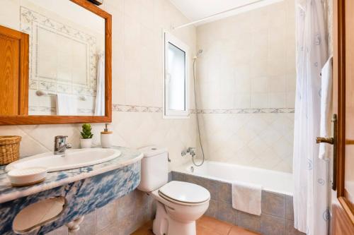 a bathroom with a toilet and a sink and a tub at Villa Santi I by Villa Plus in Cala en Porter