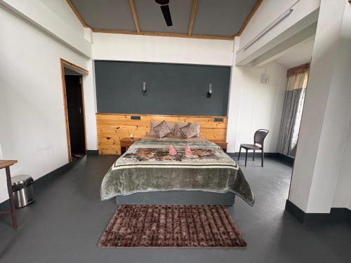 a bedroom with a large bed and a chair at West corner B Homestay in Mawlynnong