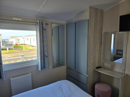 a bedroom with a bed and a window at Palm trees and the sea in Reighton
