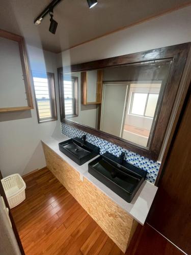 a bathroom with two sinks and a large mirror at 118 Terrace in Nakijin