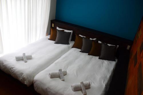 two beds with crosses on them in a bedroom at 118 Terrace in Nakijin