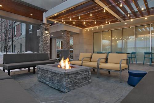 a patio with couches and a fire pit at Home2 Suites by Hilton Anchorage/Midtown in Anchorage