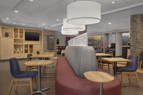 a restaurant with tables and chairs and a tv at Home2 Suites by Hilton Anchorage/Midtown in Anchorage