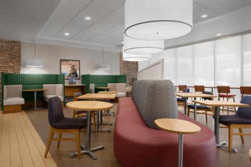 a waiting room with tables and chairs at Home2 Suites by Hilton Anchorage/Midtown in Anchorage