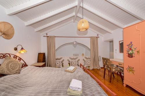 a bedroom with a bed and a table and chairs at Astrelis Emerald Villa - Cozy House Walking Distance to the Beach in Kalyves