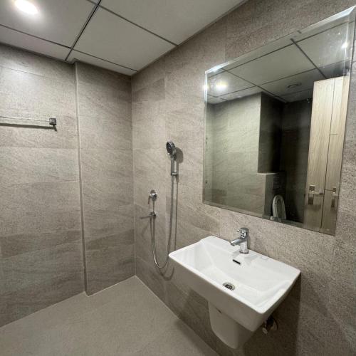 a bathroom with a sink and a shower with a mirror at Stayverse noida in Greater Noida