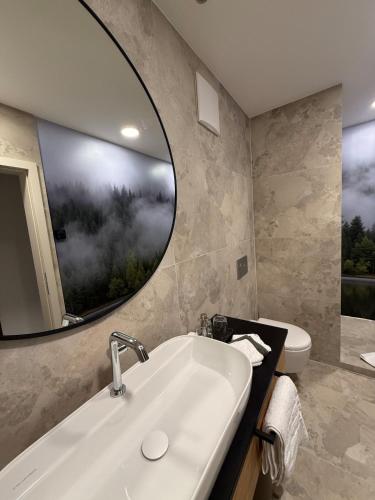 a bathroom with a sink and a mirror at "Unter Freunden", Design Meets Allgäu in Wertach