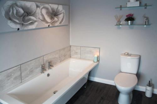 a bathroom with a bath tub and a toilet at The Windmill Inn - Whitby in Whitby