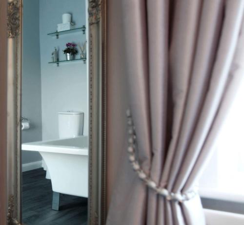 a mirror in a bathroom with a shower curtain at The Windmill Inn - Whitby in Whitby