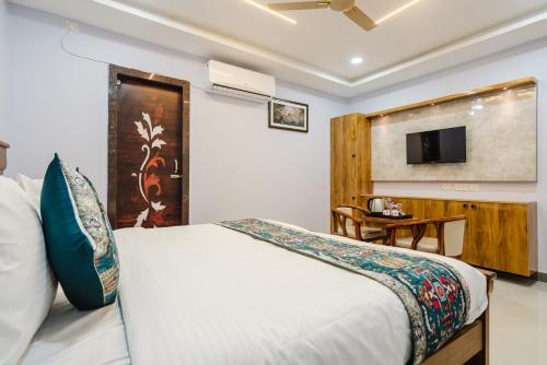 a bedroom with a bed and a tv on the wall at Hotel Prestige Grand, Manikonda in Haidar Sāhibgūda
