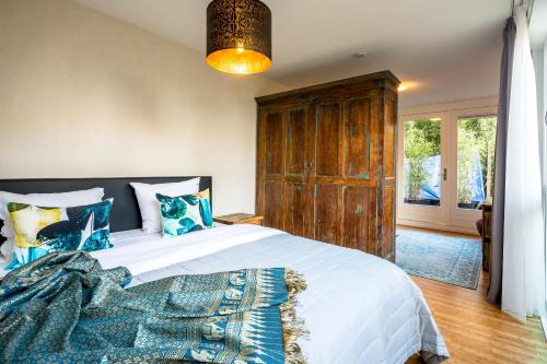 Rieteiland B&B في أمستردام: غرفة نوم مع سرير كبير مع خزانة خشبية