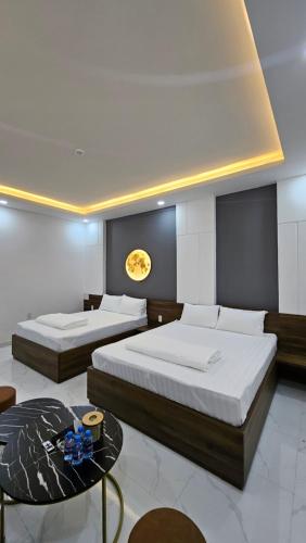 a bedroom with two beds and a table in it at The Moon Hotel in Chánh Long