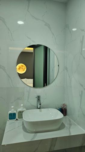 a white bathroom with a sink and a mirror at The Moon Hotel in Chánh Long