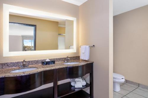 a bathroom with two sinks and a mirror at Holiday Inn Quincy by IHG in Quincy