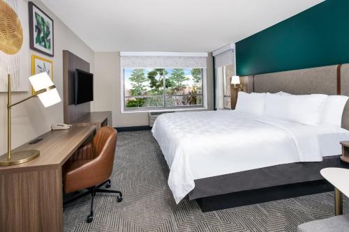 a hotel room with a large bed and a desk at Holiday Inn Quincy by IHG in Quincy