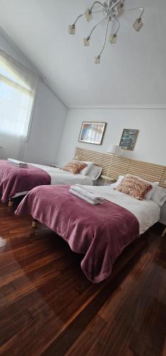 two beds in a white room with a ceiling at LURRA Tierra Apartamento 1 in Sopuerta