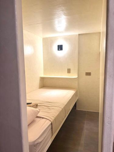 a small bedroom with a bed in a small room at Poddwell Siquijor in San Juan