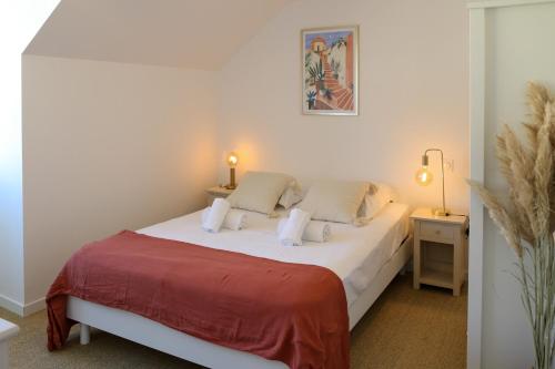 a bedroom with a white bed with a red blanket at Azur Cancale in Cancale