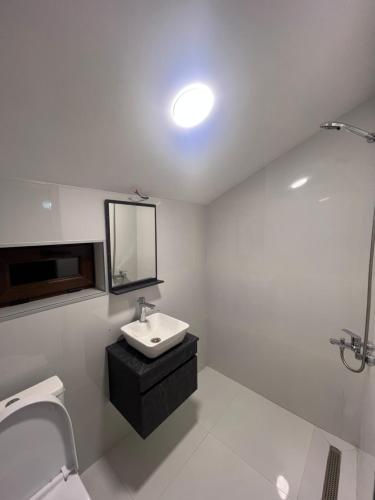 a white bathroom with a sink and a mirror at Mtskheta View Hotel in Mtskheta