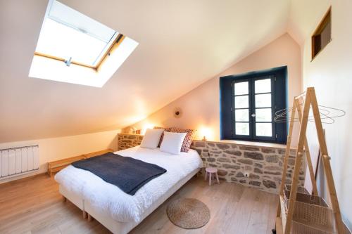 a bedroom with a bed and a window at Le petit ordinaire in Le Cours