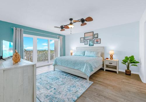 a bedroom with a bed and a balcony at Boardwalk 205 in Cocoa Beach