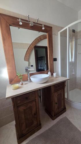 a bathroom with a sink and a large mirror at The Cozy Nest in Santa Maria a Monte