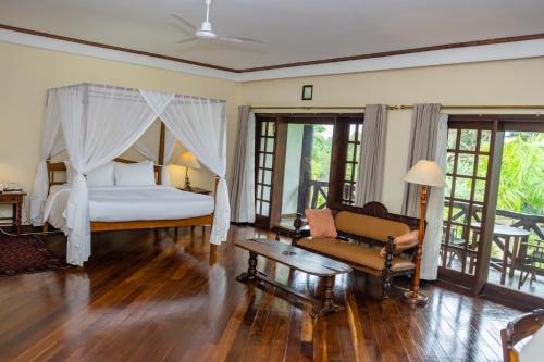 a bedroom with a bed and a couch and a table at Safari Park Hotel in Nairobi
