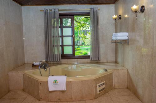 a large bathroom with a tub and a window at Safari Park Hotel in Nairobi