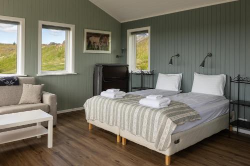 a bedroom with a bed and a couch and windows at Hestheimar in Hella