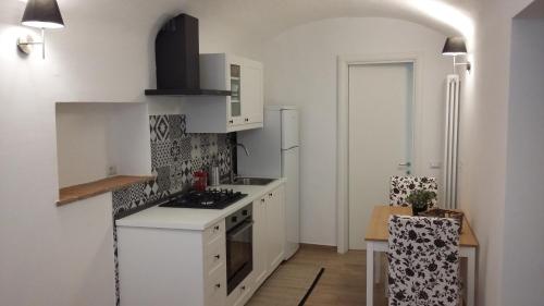 cocina con armarios blancos y fogones en Appartamento Clementini en Orvieto