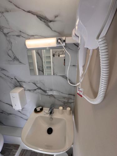 ein Badezimmer mit weißer Toilette und Spiegel in der Unterkunft Hôtel OpalOriental Boulogne Sur Mer - gare ville et centre in Boulogne-sur-Mer