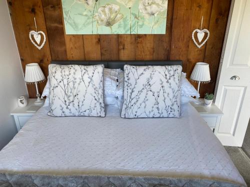 a bedroom with a bed with white sheets and pillows at Chalet Thirty Two in Seaton
