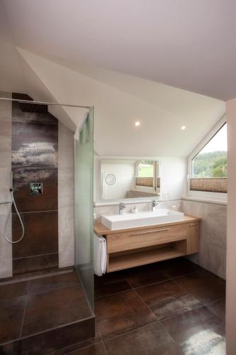 a bathroom with a tub and a sink and a shower at Das Landhaus Apartments in Prüm