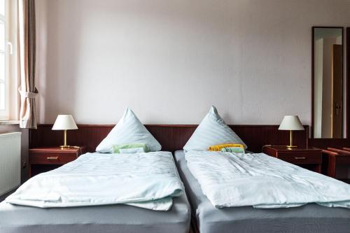 two beds with white sheets and pillows in a room at Monteurzimmer Jerichow in Jerichow