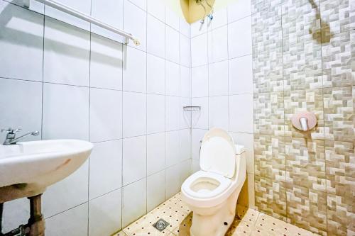 a bathroom with a toilet and a sink at RedDoorz at Hotel Dieng Berastagi in Berastagi