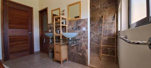 a bathroom with two sinks and a walk in shower at Les Villas Thorel - Hibiscus in Rivière Noire