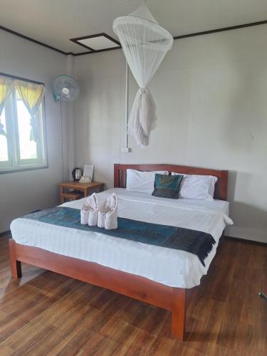a bedroom with a large bed with shoes on it at Champa resort in Don Det