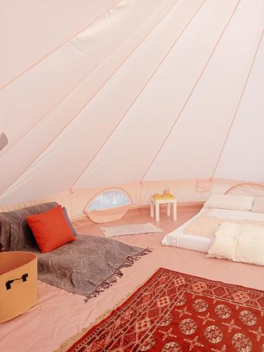 a room with a bed and a couch in a tent at Wishne Glamping Agriturismo in tende Bisceglie in Bisceglie