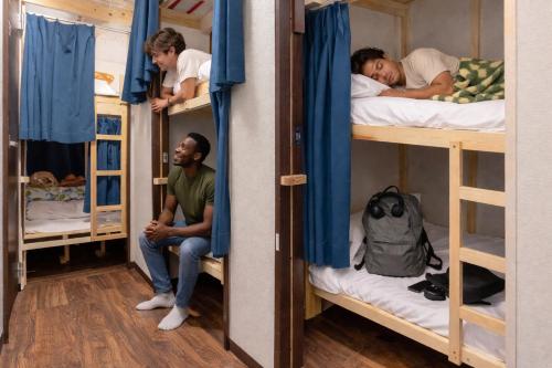 a group of people sleeping in bunk beds at Akabane Dormitory-Men Only in Tokyo