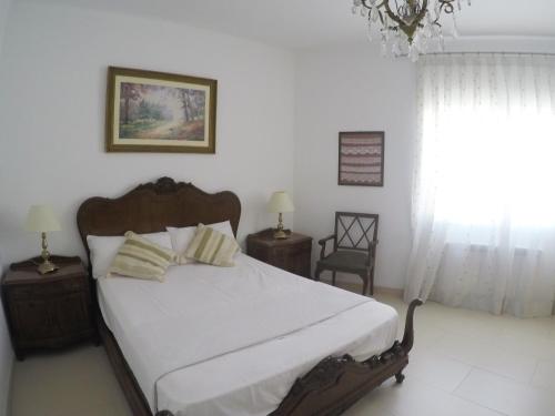 1 dormitorio con cama y lámpara de araña en Aiguaneu Sa Palomera, en Blanes