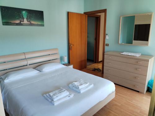 a bedroom with a large white bed and a dresser at home sweet home in Buia