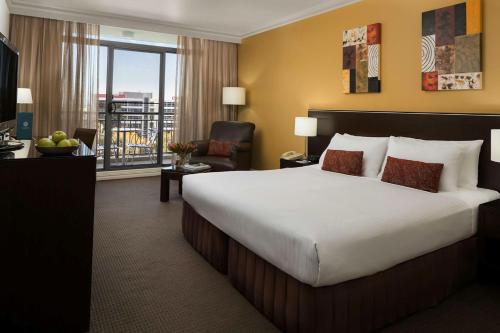 a hotel room with a large bed and a balcony at Visy Dior in Baulkham Hills