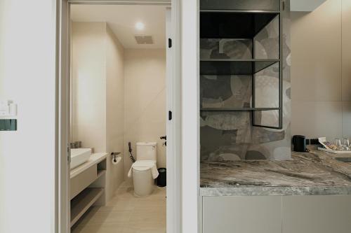 a bathroom with a toilet and a sink at After Rain Hotel in Chiang Mai