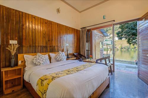 a bedroom with a large bed and a large window at By the Lakeside in Bhīm Tāl