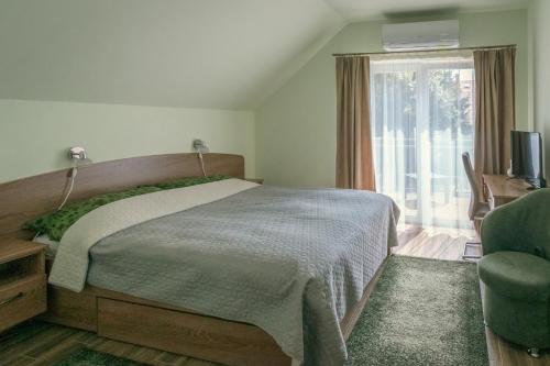 a bedroom with a bed and a tv and a window at Rév-Panzió in Abádszalók
