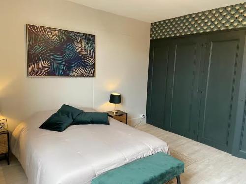 a bedroom with a white bed and a painting on the wall at Escales patrimoniales en cœur de ville in Poitiers