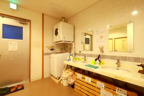 a kitchen with two sinks and a refrigerator at Minshuku Irayoi in Ishigaki Island