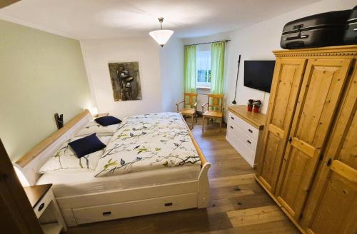 a bedroom with a bed and a television in it at HOME4GOLF Uttlau in Bad Griesbach